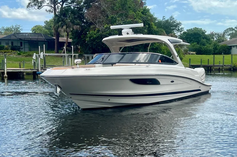 Slide: The Image of 2017 Sea Ray SLX 350 Outboard boat on calm water, surrounded by greenery. - 4