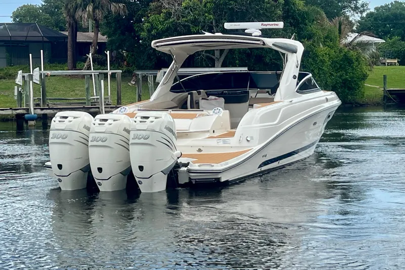 Slide: The Image of 2017 Sea Ray SLX 350 Outboard boat with triple engines on a calm waterway. - 6