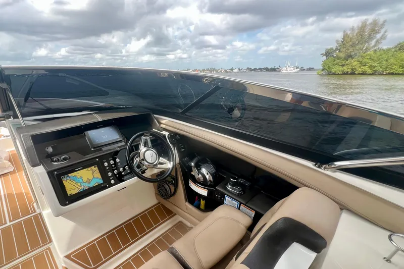Slide: The Image of 2017 Sea Ray SLX 350 Outboard helm with navigation system, steering wheel, and scenic water view. - 8