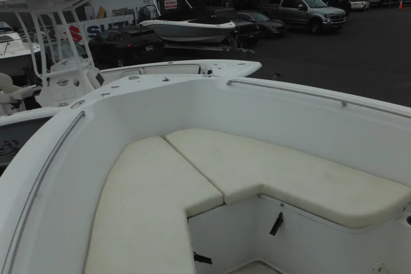 Slide: The Image of 2005 Sailfish 218 CC boat interior with cushioned seating, parked in a marina. - 10