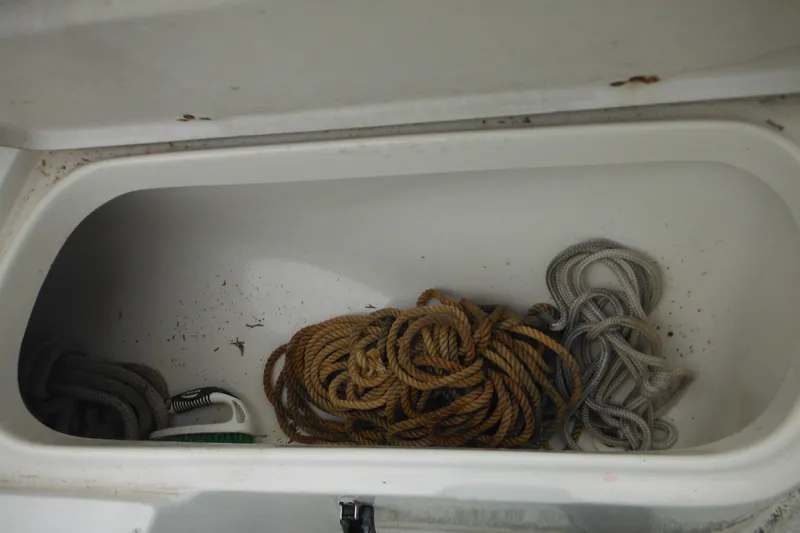 Slide: The Image of Storage compartment with ropes and brush on a 2005 Sailfish 218 CC boat. - 15