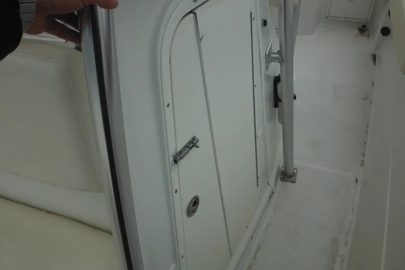 Slide: The Image of 2005 Sailfish 218 CC boat interior with white seating and storage compartment. - 18
