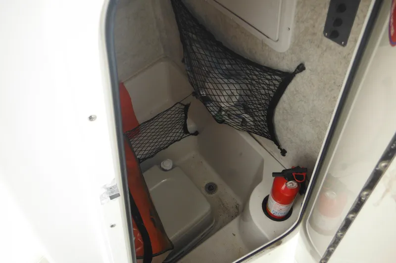 Slide: The Image of Interior of a 2005 Sailfish 218 CC boat with storage nets and fire extinguisher. - 19