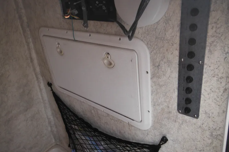 Slide: The Image of Interior of 2005 Sailfish 218 CC boat showing storage compartment and control panel. - 20