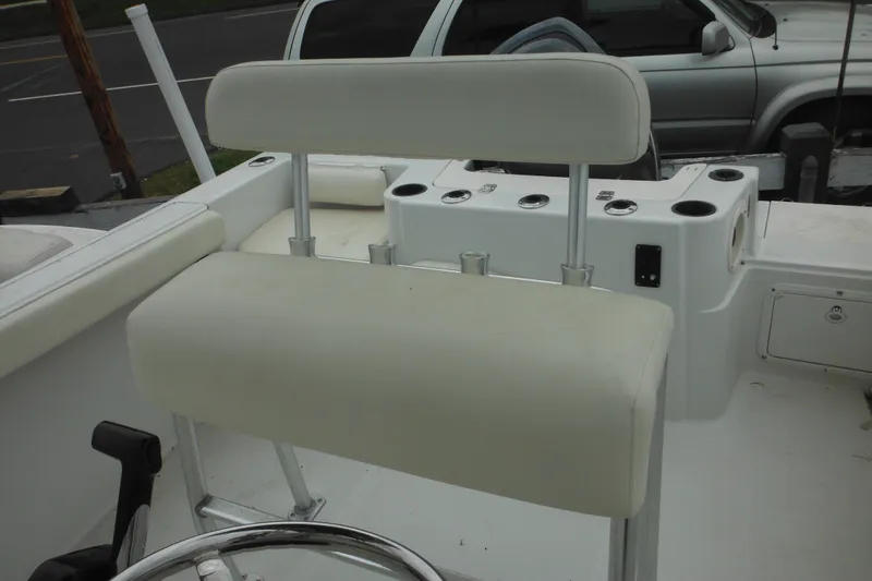 Slide: The Image of 2005 Sailfish 218 CC boat interior with white cushioned seating and steering wheel. - 21