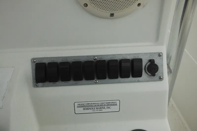 Slide: The Image of Control panel of a 2005 Sailfish 218 CC boat with switches and a 12V outlet. - 26