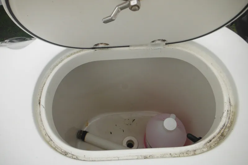 Slide: The Image of Open storage compartment on 2005 Sailfish 218 CC boat with cleaning supplies inside. - 37