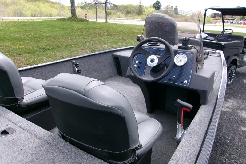 Slide: The Image of 2023 Tracker Bass Tracker Classic XL boat interior with steering wheel and seats. - 2
