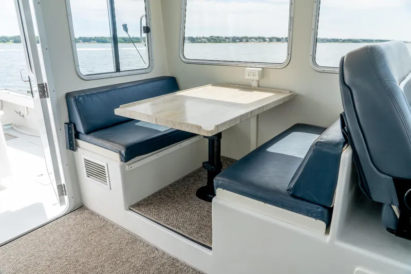 Slide: The Image of Interior of 2018 Northern Bay 38 boat with blue seating and table, overlooking water. - 35