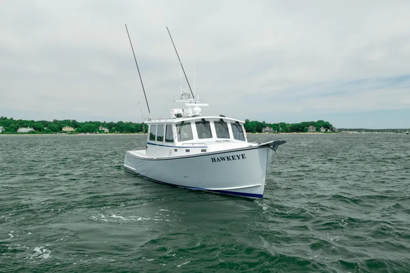 Slide: The Image of 2018 Northern Bay 38 boat named "Hawkeye" on open water, with coastal background. - 5