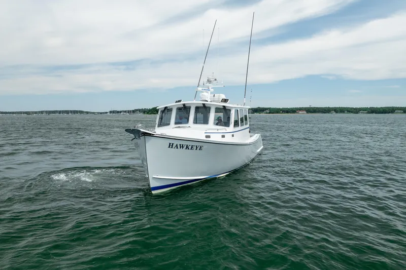 Slide: The Image of 2018 Northern Bay 38 boat "Hawkeye" cruising on open water under a cloudy sky. - 16