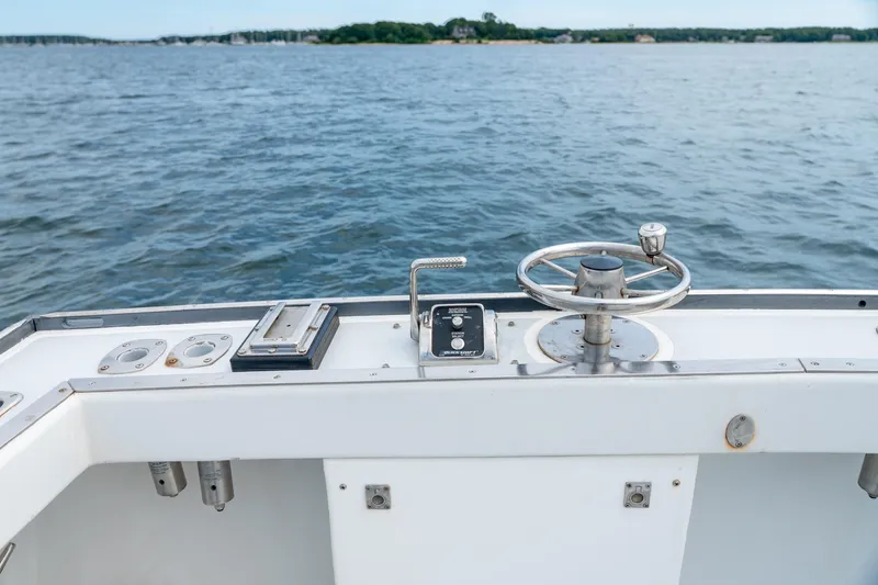 Slide: The Image of Steering wheel and controls on a 2018 Northern Bay 38 boat, overlooking calm waters. - 25