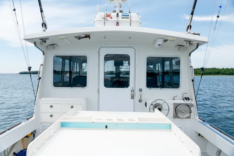 Slide: The Image of 2018 Northern Bay 38 boat on calm water, showcasing rear deck and cabin. - 26