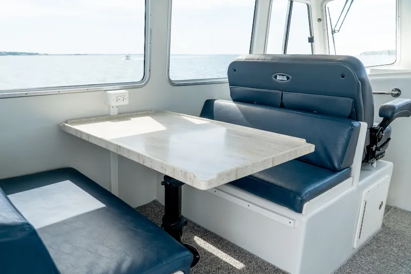 Slide: The Image of Interior of 2018 Northern Bay 38 boat with blue seating and a table. - 28