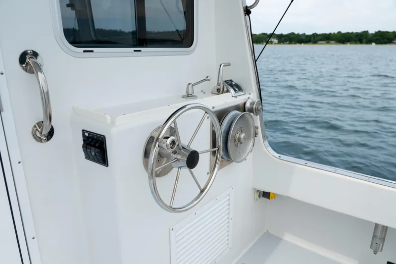 Slide: The Image of Steering wheel of a 2018 Northern Bay 38 boat, overlooking calm waters. - 19