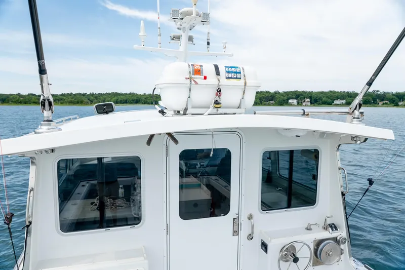 Slide: The Image of 2018 Northern Bay 38 boat on water, featuring fishing rods and life raft. - 23
