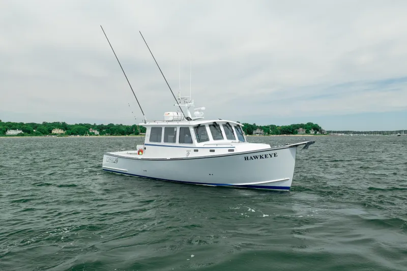 Slide: The Image of 2018 Northern Bay 38 boat named "Hawkeye" on open water, with coastal background. - 6