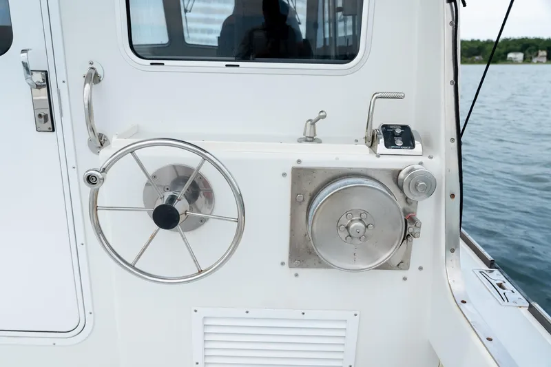 Slide: The Image of Steering wheel and controls on a 2018 Northern Bay 38 boat, docked by the water. - 20