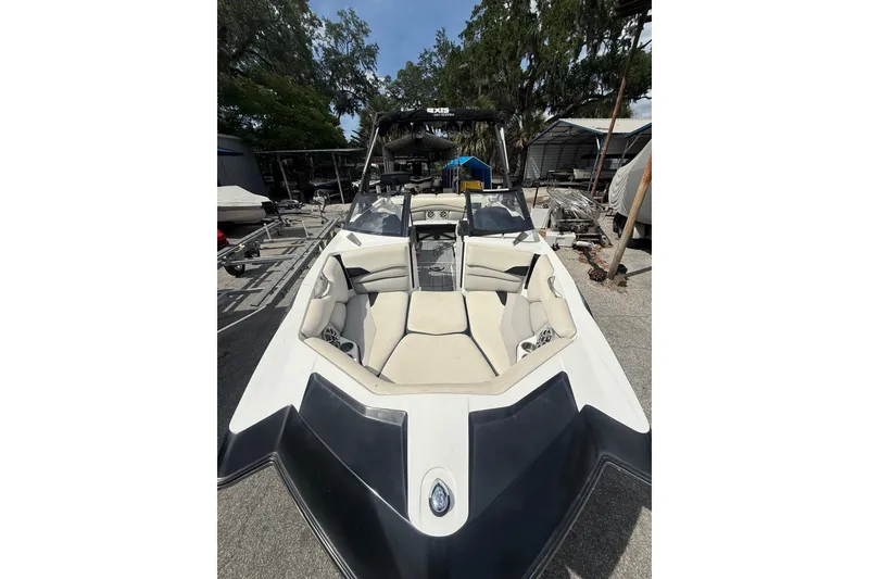 Slide: The Image of 2016 Axis A22 boat with beige seating, parked outdoors. - 3