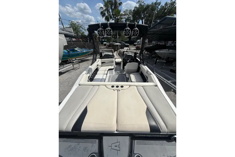Slide: The Image of 2016 Axis A22 boat interior with seating and speakers, docked outdoors. - 4