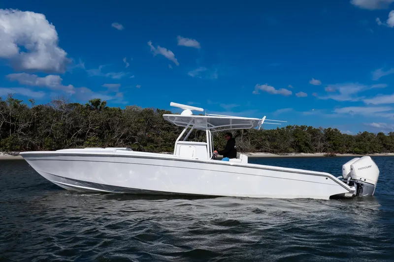 Slide: The Image of 1997 Marlago 35fs boat cruising on water under a clear blue sky. - 2