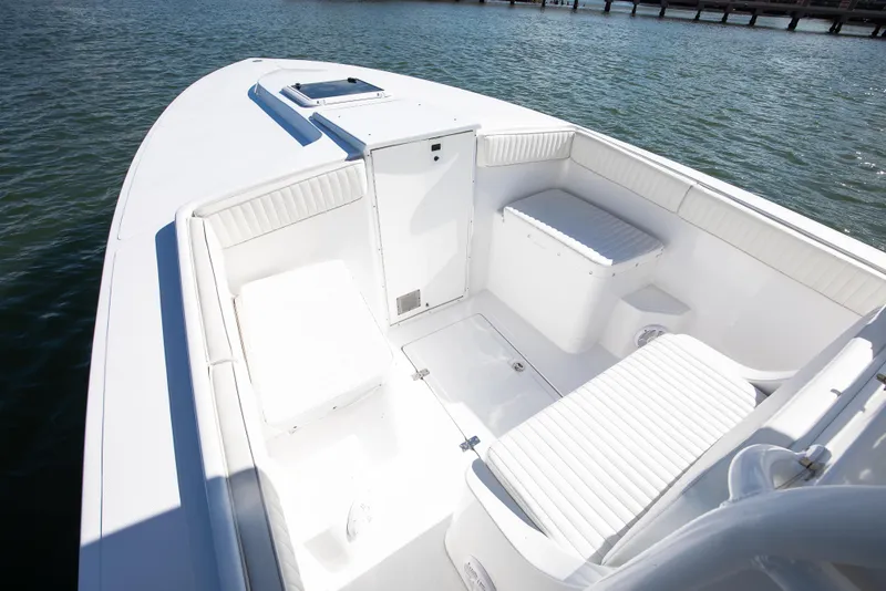 Slide: The Image of 1997 Marlago 35fs boat interior with white seating, docked on calm water. - 7