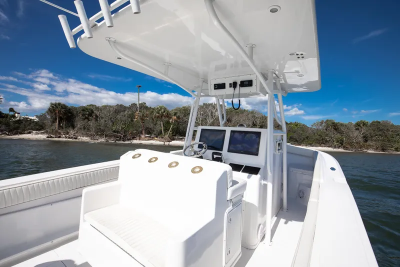 Slide: The Image of 1997 Marlago 35fs boat interior with helm, white seating, and ocean backdrop. - 8