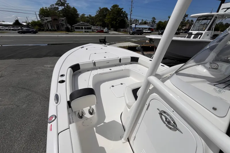 Slide: The Image of 2026 Tidewater 2300 Carolina Bay boat interior with seating and console, parked outdoors. - 10