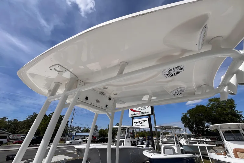 Slide: The Image of 2026 Tidewater 2300 Carolina Bay boat with T-top and speakers, displayed outdoors. - 8