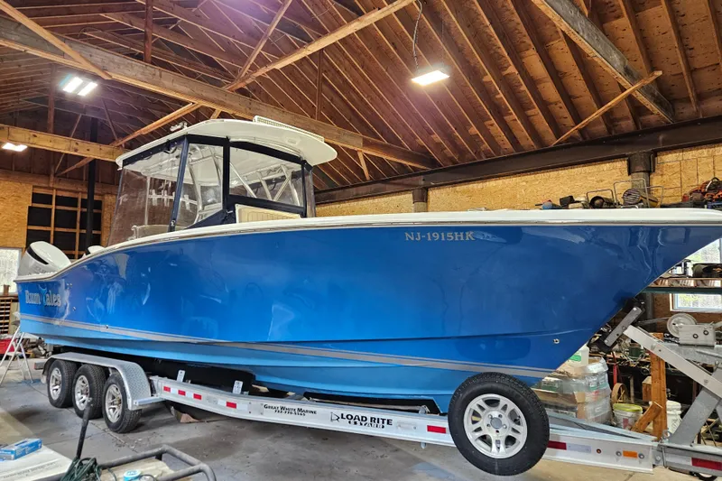 The Image of 2018 Jersey Cape 31 Little Devil boat in a wooden garage on a trailer. - 1