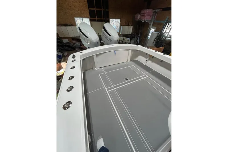 Slide: The Image of 2018 Jersey Cape 31 Little Devil boat interior with dual outboard motors in a garage. - 4