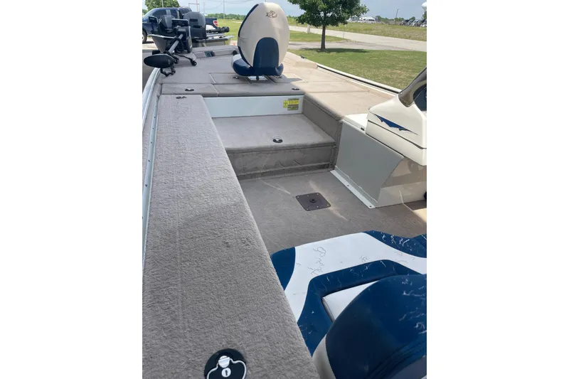 Slide: The Image of 2007 Duracraft 188dlx boat interior with blue and white seating, parked outdoors. - 3