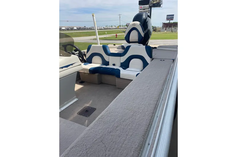 Slide: The Image of 2007 Duracraft 188dlx boat interior with blue and white seating, parked outdoors. - 4