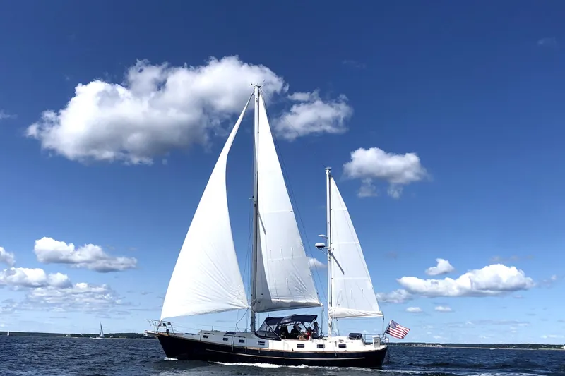 The Image of 1980 Morgan 462 sailboat cruising on open water under a clear blue sky. - 0