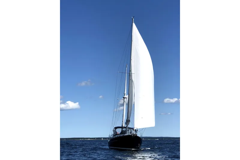 Slide: The Image of Sailing yacht Morgan 462 (1980) with white sails on open water under clear blue sky. - 1
