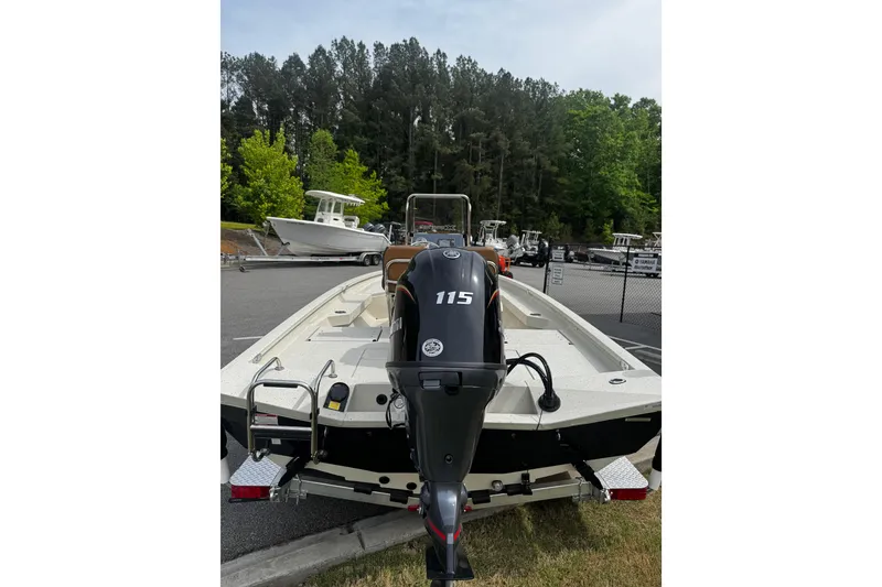 Slide: The Image of 2026 Xpress H20B Bay boat with 115 horsepower engine, parked outdoors near trees. - 12