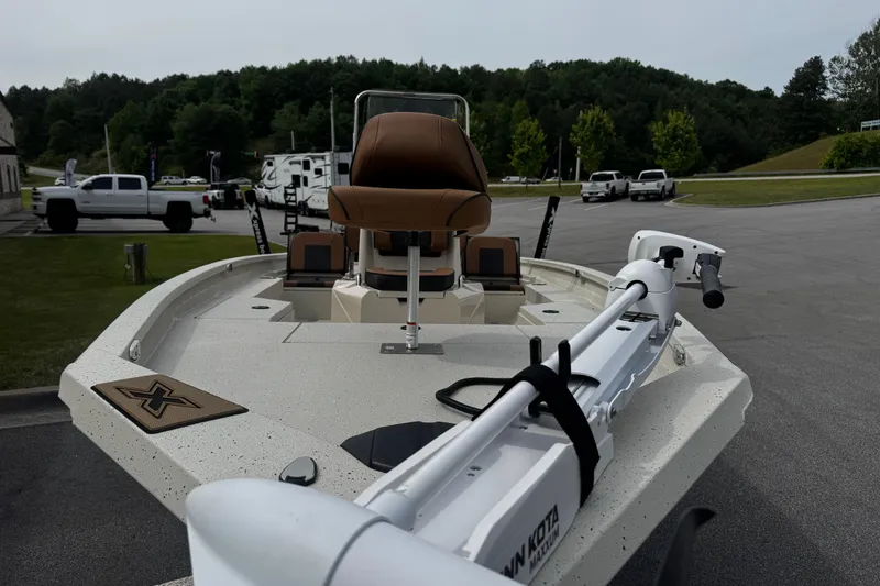 Slide: The Image of 2026 Xpress H20B Bay boat with trolling motor, parked outdoors. - 21