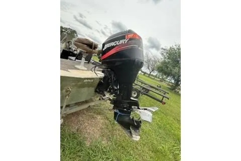 Slide: The Image of 2005 Fisher 1754 AWL boat with Mercury outboard motor on grassy area. - 11