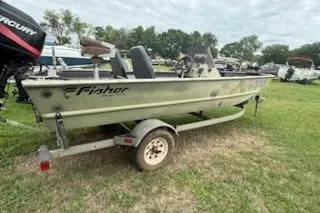 Slide: The Image of 2005 Fisher 1754 AWL boat on trailer, parked on grass with trees in background. - 2