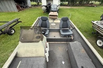 Slide: The Image of 2005 Fisher 1754 AWL boat interior with dual seats and steering console on grass. - 5