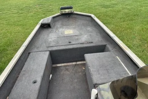 Slide: The Image of 2005 Fisher 1754 AWL boat interior with gray seating on grass. - 7