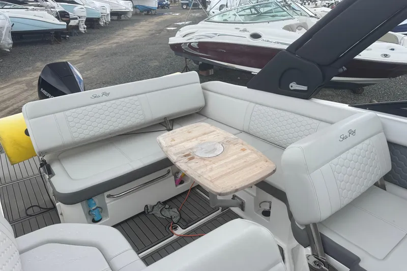 Slide: The Image of 2024 Sea Ray SDX 250 Outboard boat interior with seating and wooden table. - 14