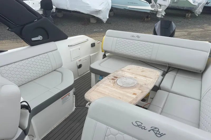 Slide: The Image of 2024 Sea Ray SDX 250 Outboard interior with luxurious seating and wooden table. - 15