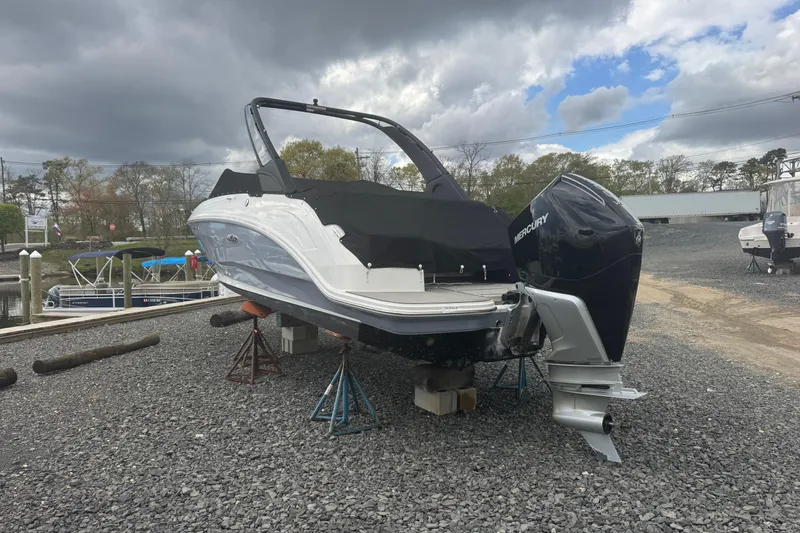 Slide: The Image of 2024 Sea Ray SDX 250 Outboard boat on gravel, covered and elevated, with Mercury engine. - 3