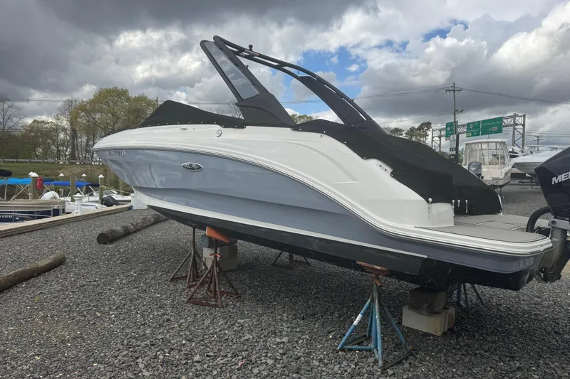 Slide: The Image of 2024 Sea Ray SDX 250 Outboard boat on stands, under cloudy sky. - 4