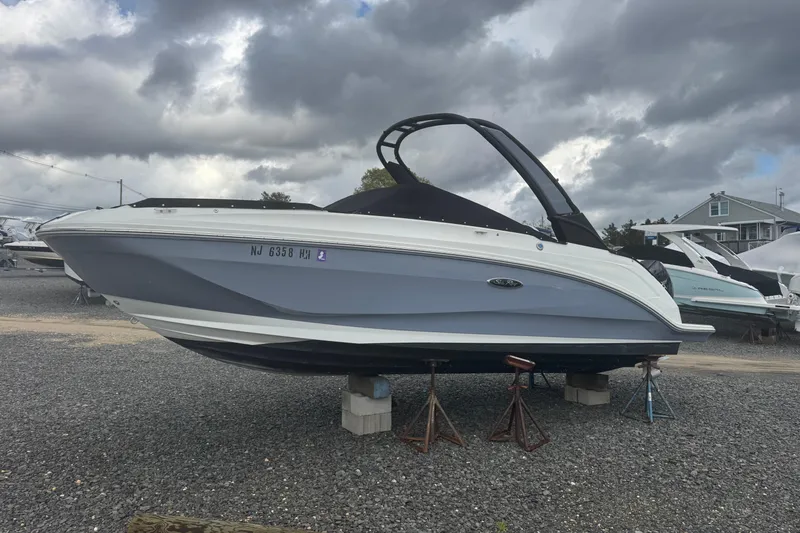 Slide: The Image of 2024 Sea Ray SDX 250 Outboard boat on stands under cloudy sky. - 5