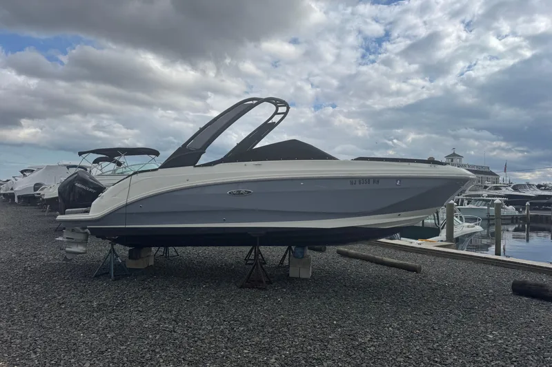 Slide: The Image of 2024 Sea Ray SDX 250 Outboard boat on display at a marina under cloudy skies. - 6