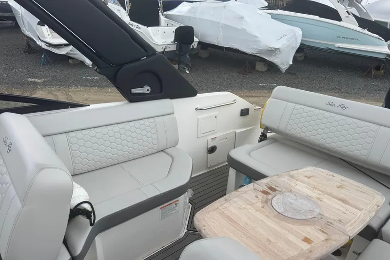 Slide: The Image of 2024 Sea Ray SDX 250 Outboard interior with luxurious seating and wooden table. - 9