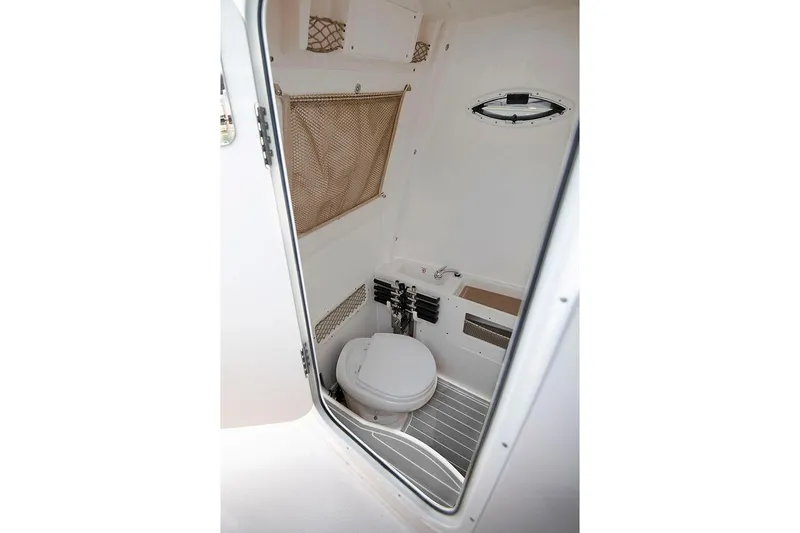 Slide: The Image of Manufacturer Provided Image: Interior view of 2026 Sailfish 272 CC boat bathroom with toilet and storage. - 6