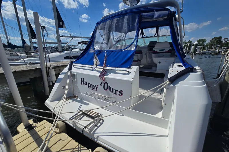 Slide: The Image of 1997 Formula 34 Performance Cruiser docked, featuring "Happy Ours" name and blue canopy. - 13